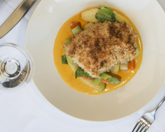 Wild Gulf Barramundi fillet baked with macadamia and coconut crust, served with vegetables, potato and a mango coconut sauce.